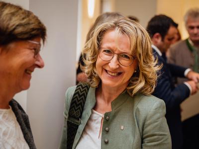 Monika Maier lachend im Gespräch mit MdL Rosi Steinberger (links, schräg von der Seite)