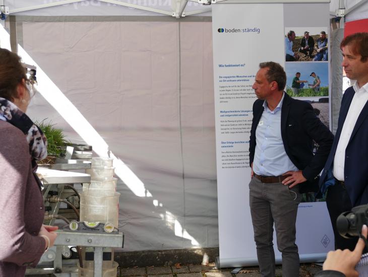 Umweltminister Thorsten Glauber informiert sich am Regensimulator über die Initiative boden:ständig