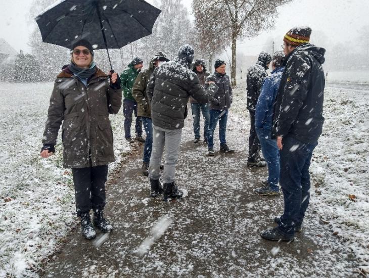 Amtsvertreter und Landwirte stehen im Schneegestöber - einzig Birgitt Wagenpfeil ist mit einem Regenschirm geschützt